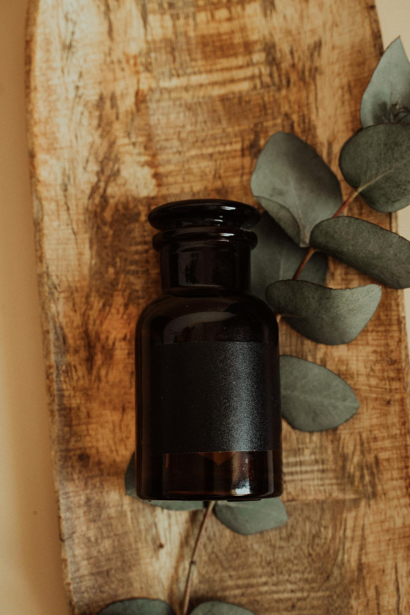 Amber supplement bottle with eucalyptus on a wooden board